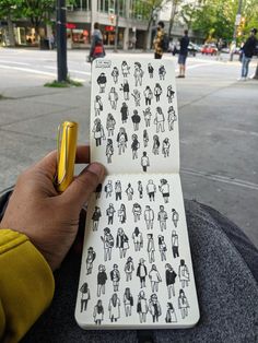 a person holding up a notebook with stickers on it and a pen in their hand