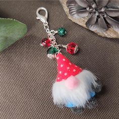 a keychain with a red hat and white fluffy skirt on it's side