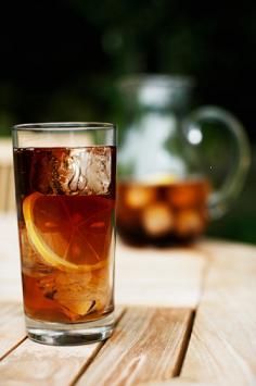 a glass filled with ice and an orange slice sitting on top of a wooden table