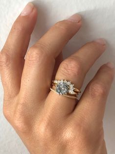 a woman's hand with a ring on it and a diamond in the middle