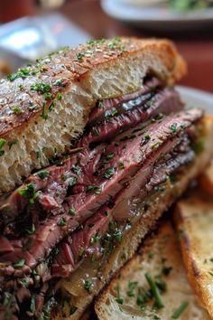 a roast beef sandwich on toasted bread with chives sprinkled on top