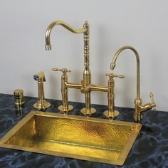 an antique brass sink and faucet set on a marble countertop