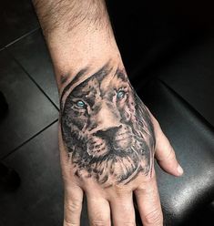 a man's hand with a tattoo on it and a lion face in the middle