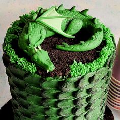 a cake with green frosting and a dragon on top