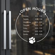 an open hours sign on the front door of a building with a dog's paw