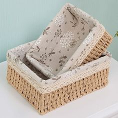 two wicker baskets sitting on top of a white table