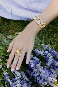 Epitomizing the beauty of a bouquet of flowers, the Wildflowers Gathered Ring is meticulously handcrafted from 18k gold-dipped brass, adorned with carefully selected colors of hand-painted enamel. A luxurious embodiment of sophistication, it effortlessly marries timeless elegance with a delightful sense of whimsy. 18K Gold Plated Brass Hand Painted Enamel 1" D Yellow Gold Enamel Jewelry With Rose Cut Diamonds, Luxury Flower-shaped Jewelry With Rose Cut Diamonds, Luxury Flower-shaped Jewelry For Wedding, Luxury Flower Jewelry For Wedding, Luxury Flower Shaped Ring For Wedding, Luxury Flower Wedding Ring, Pink Enamel Ring For Wedding, Yellow Gold Enamel Flower Jewelry, Elegant Enamel Open Ring Jewelry