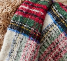 a close up view of a blanket on a furry surface with the colors of red, green, yellow and blue