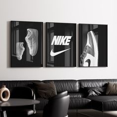 three black and white pictures hang on the wall above a couch in a living room