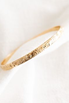 14k gold filled floral patterned bangle If you would like a different length that is not listed, please contact us for a custom order! Please note that there may be slight color variations or a seam where the joints of the bangle has been soldered. Since this piece is handmade, keep in mind that solder marks are visible and is totally normal. Finding Your Size We recommend using a flexible measuring tape to wrap around your hand/knuckles to find the length of your preferred fit. An alternative to this is getting a piece of string or shoelace, wrap that around your hand/knuckles, and measure the length in inches Ex: If the measuring tape/string is measured to be 7 inches, your bangle size is a size 7 14k Gold Bangle Bracelet With Intricate Design, 14k Gold Bracelets With Intricate Design For Wedding, 14k Gold Wedding Bracelets With Intricate Design, 14k Gold Bracelet With Intricate Design For Gift, 14k Gold Bangle With Intricate Design As Gift, 14k Gold Bangle For Wedding, Intricate 14k Yellow Gold Bangle, 14k Yellow Gold Bangle With Intricate Design, Adjustable 14k Gold Jewelry With Intricate Design