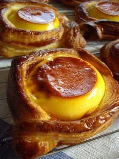 some very tasty looking pastries sitting on a cooling rack with jelly in them