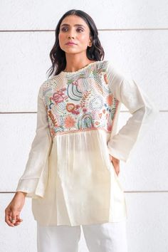 Ivory tunic top featuring multi-color thread embroidery on the yoke in abstract pattern. - Aza Fashions Spring Tunic Top With Intricate Embroidery, Bohemian Beige Top With Chikankari Embroidery, Cotton Tunic Tops With Intricate Embroidery, White Resham Embroidery Long Sleeve Tunic, Traditional Beige Tops With Chikankari Embroidery, Bohemian Multicolor Tops With Chikankari Embroidery, White Long Sleeve Tunic With Resham Embroidery, Multicolor Long Sleeve Tunic With Floral Embroidery, Bohemian Multicolor Chikankari Embroidery Tops