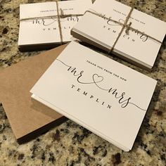 wedding stationery cards tied with twine on top of each other, sitting on a granite countertop