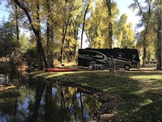 a camper parked next to a river in the woods