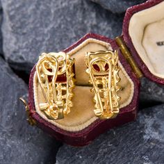 These elegant earrings feature east-to-west set emerald cut garnets set atop woven gold that gracefully curves beneath the bottom of the ear. They are crafted in 14k yellow gold and are finished with posts and omega backs for pierced ears. Art Deco Clip-on Jewelry For Formal Occasions, Clip-on Art Deco Jewelry For Formal Occasions, Formal Art Deco Clip-on Jewelry, Gold Gemstone Clip-on Earrings For Formal Occasions, Formal Gold Gemstone Clip-on Earrings, Formal Yellow Gold Gemstone Clip-on Earrings, Luxury 14k Gold Emerald Cut Earrings, Luxury Yellow Gold Emerald Cut Earrings, Diamond Yellow Gold Clip-on Earrings Gift