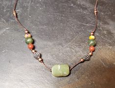 Jade center bead. Delicate (but durable adjustable length necklace. Simple with beautiful colors Artisan Necklace With Adjustable Cord For Healing, Adjustable Jade Beaded Necklaces, Adjustable Jade Pendant Necklace, Adjustable Gemstone Beads Necklace For Healing, Adjustable Casual Pendant Necklace, Casual Adjustable Pendant Necklace, Adjustable Jade Beaded Necklaces With Natural Stones, Adjustable Multicolor Jade Necklaces, Earthy Necklace With Adjustable Cord For Healing