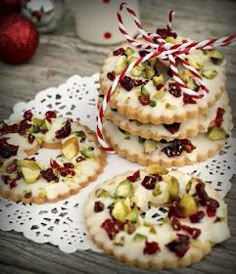 cookies decorated with white icing and dried pistachios on a doily