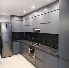 a kitchen with gray cabinets and marble counter tops