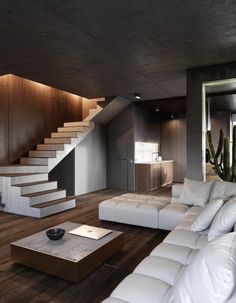 a living room filled with white furniture next to a stair case and wooden flooring