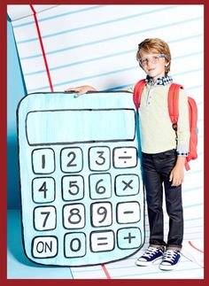 a young boy standing next to a drawing of a calculator