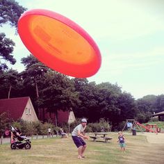 a man is throwing a frisbee in the air at a park with other people