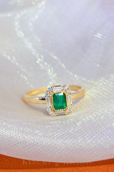 Formal Emerald Ring With Rectangular Stone, Elegant Rectangular Emerald Ring With Center Stone, Fine Jewelry Rectangular Emerald Ring, Rectangular Gold Emerald Ring, Elegant Emerald Ring With Rectangular Diamond, Rectangular Halo Setting Rings In Fine Jewelry, Rectangular Halo Setting Fine Jewelry Rings, Classic Rectangular Emerald Ring With Center Stone, Rectangular Halo Setting Fine Rings