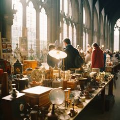 people looking at antique items on tables in an old building