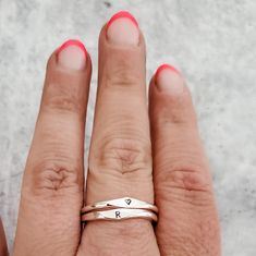 This dainty and charming ring is hand-crafted from high-quality sterling silver, ensuring both durability and style. Choose your favorite initial to be hand stamped on the ring, making it a delightful and meaningful gift for yourself or someone special. With meticulous precision, we create a unique design that adds a playful flair to the ring's overall allure. Express your individuality and show off your style by stacking this fabulous Sterling Silver Initial Ring with other favorites. Whether y Simple Anniversary Rings With Initials, Simple Anniversary Ring With Initials, Minimalist Stackable Rings With Initials For Anniversary, Minimalist Stackable Initial Ring For Promise, Tiny Rose Gold Midi Rings In Sterling Silver, Tiny Rose Gold Sterling Silver Midi Rings, Minimalist Stackable Initial Promise Ring, Rose Gold Sterling Silver Stackable Promise Rings, Minimalist Sterling Silver Stackable Rings For Anniversary