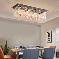 a dining room table with chairs and a chandelier hanging from it's ceiling