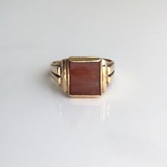 An art deco 9 carat yellow gold signet ring displaying a charming carnelian stone. The gold has a heavy look about it, creating a great combination for a bold signet ring. CONDITION: Good condition, wear consistent with age and use. Stone in great condition. Please see photos for more detail. HALLMARKED 9 CARAT GOLD, ASSAYED IN BIRMINGHAM 1939 RING SIZE: UK: X 1/2 | US: 11 3/4 BAND WIDTH (NARROWEST): 3mm STONE FACE: 12mm x 10mm WEIGHT: 5.8 grams Formal Carnelian Signet Ring With Polished Finish, Classic Carnelian Signet Ring With Polished Finish, Antique Red 14k Gold Signet Ring, Antique Red Signet Ring In 14k Gold, Classic Carnelian Signet Ring For Formal Occasions, Classic Carnelian Signet Ring For Formal Events, Modern Gold Signet Ring With Cabochon, Antique Red Gemstone Signet Ring, Classic Carnelian Rings With Polished Finish