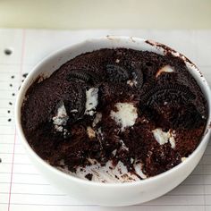 a white bowl filled with cookies and oreo cookies on top of a notepad