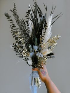 a person holding a bouquet of flowers in their left hand and the other hand with something on it