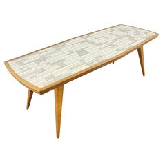 a wooden table with white tile on top and legs in the shape of a triangle