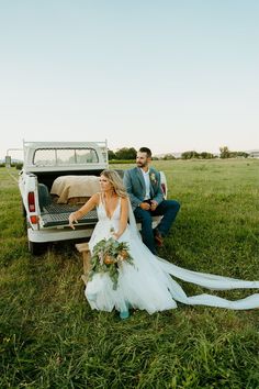 a bride and groom sitting in the back of a pick up truck