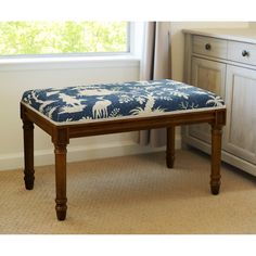 a blue and white bench sitting in front of a window next to a dresser with drawers