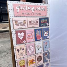 a sign that has greeting cards on it