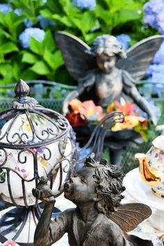 an angel figurine sitting on top of a table next to a birdcage