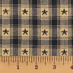 a ruler is next to a blue and white checkered fabric with black crosses on it