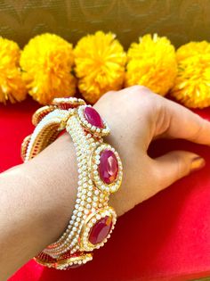 "Beautiful ruby red and pearl jadau royal Rajasthani statement kada. Its a Statement kada selling as single piece. It has side hinge to open it too as needed for your comfort. 2.6\" , 2.4\" size available in red 2.6\" in green." Elegant Bangle With Zari Work, Elegant Zari Work Bangle, Traditional Pearl Bracelet For Wedding And Festivals, Ruby Bracelets With Stone Work For Wedding, Traditional Pearl Bracelet For Wedding And Festive Occasions, Festive Ruby Bangle For Wedding, Red Bangle With Zari Work For Diwali, Chandbali Bangle With Stone Work For Puja, Red Zari Work Bracelets For Festive Season