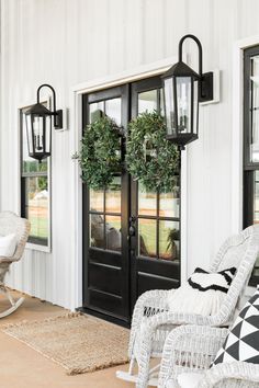 the front door is decorated with wreaths and chairs