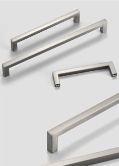 three different types of handles and pulls on a white surface, one is stainless steel