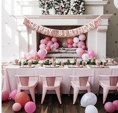 a birthday party set up with pink and white balloons