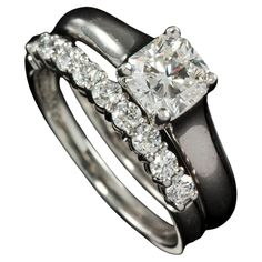 an engagement ring set with a princess cut diamond in the center and side stones on each band