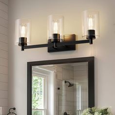 a bathroom vanity with two lights and a mirror