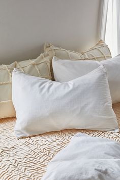 four white pillows sitting on top of a bed