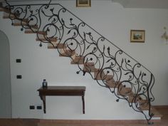 a staircase with wrought iron railing and wooden table