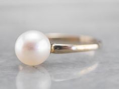 This pearl solitaire ring will be a classic for years to come! The pearl shimmers to perfection, with a glowing ghostly white hue. Crafted from 18 karat white gold, this ring is refined beauty at its very best! Metal: 18K White Gold Gem: Pearl Gem Measurements: 6.6 mm, Round Ring Size: 5 Marks: "18K" Stamped on the inside band Yellow Gold Sapphire Ring, White Gold Solitaire, Pearl And Diamond Ring, Gold Solitaire Ring, Round Rings, The Pearl, June Birth Stone, Pearl Ring, Eternity Bands