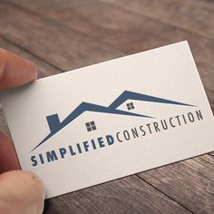 a hand holding up a business card that reads simplied construction