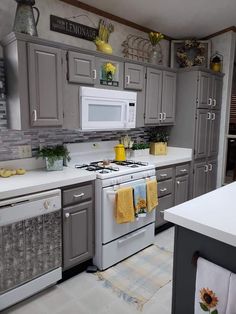 a white stove top oven sitting inside of a kitchen next to a sink and microwave