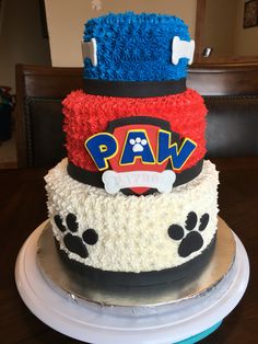 a three tiered cake with paw print on the front and paws on the back